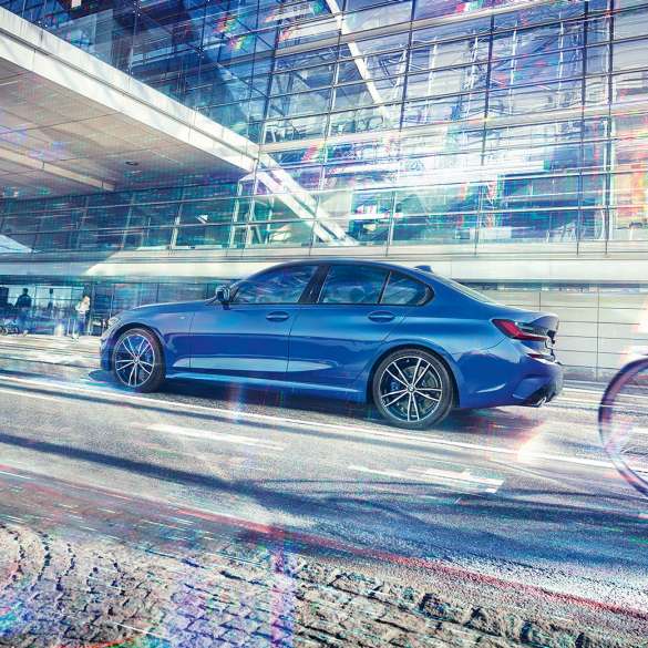 BMW סידרה 3, מבט צד. תצלום סטילס של BMW סידרה 3 במבט צד, ביום, בחזית של מבנה זכוכית.