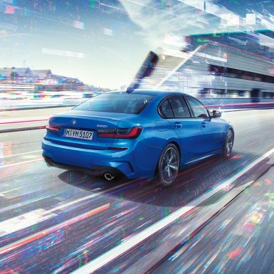 BMW סידרה 3, תצלום במבט אחור-צד. תצלום במבט אחור-צד של BMW סידרה 3 ביום, על רקע סביבה עירונית.