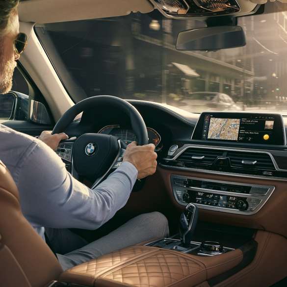 תפקודי הקישוריות ב-BMW סידרה 7 BMW סידרה 7: אדם יושב ב-BMW ומשתמש בתפקודי הקישוריות