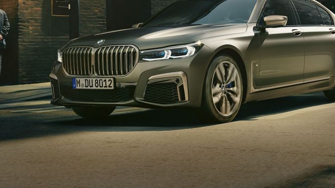 BMW M760Li xDrive בסביבה עירונית BMW M760Li xDrive במבט חזית-צד נוסעת ברחוב, בסביבה עירונית