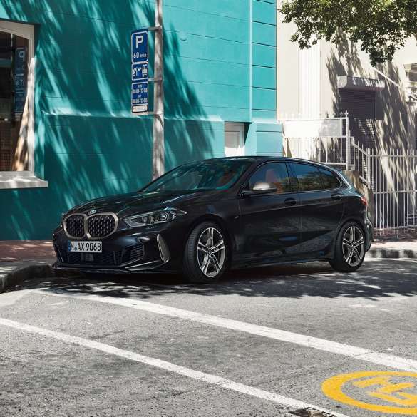 BMW M135i xDrive, מבט 3/4 צדדי. ה-BMW M135i xDrive החדשה בשחור מטאלי Sapphire, מבט 3/4 צדדי בחניה.