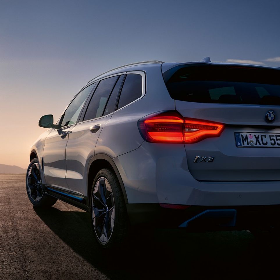 BMW iX3 מבט 3/4 אחורי על הכביש ה-BMW iX3 לבן Mineral, מבט 3/4 אחורי על הכביש