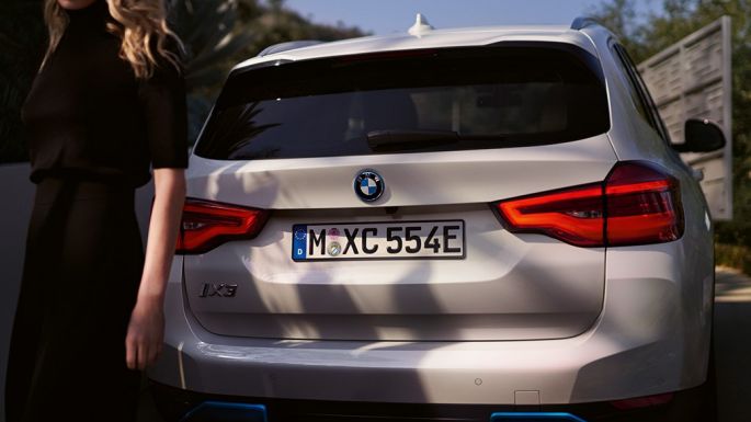 חלק אחורי עם הדיפוזר המיוחד של BMW i BMW iX3 מבט מאחור עם אישה חלק אחורי עם הדיפוזר המיוחד של BMW i BMW iX3 2020 לבן Mineral מבט מאחור עם אישה