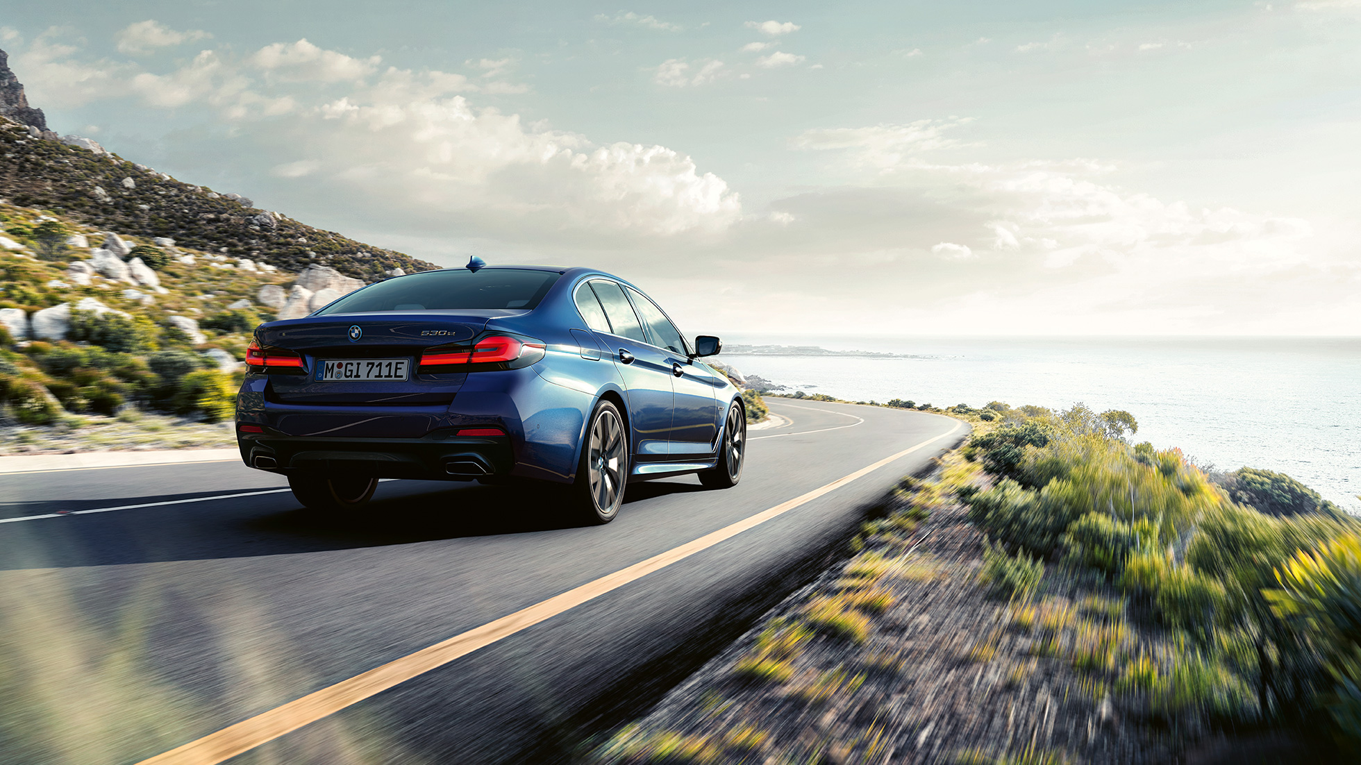 יכולות נהיגה דינמיות BMW סדרה 5 יכולות נהיגה דינמיות BMW סדרה 5 בכחול Phytonic , מבט 3/4 אחורי בנסיעה