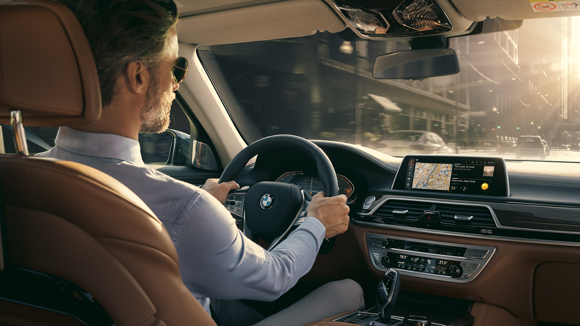 תפקודי הקישוריות ב-BMW סידרה 7 BMW סידרה 7: אדם יושב ב-BMW ומשתמש בתפקודי הקישוריות
