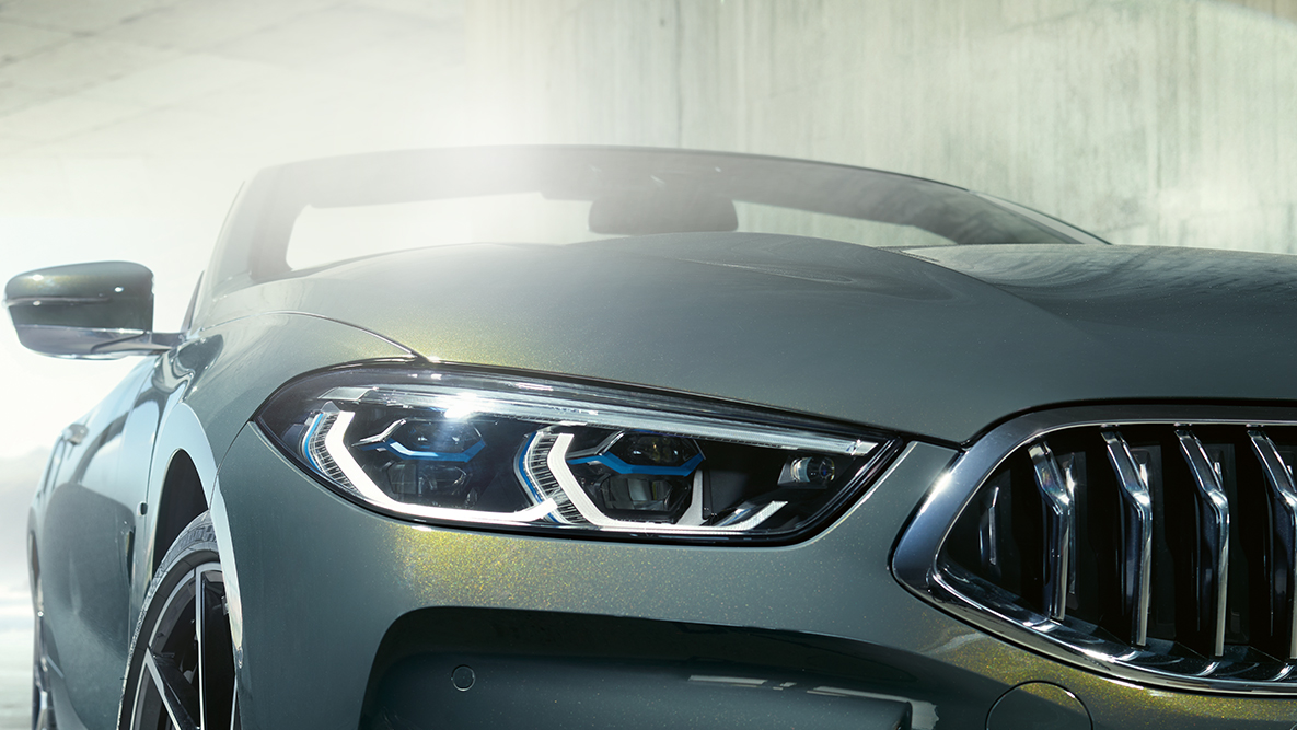 BMW M850i xDrive בצבע Dravit Grey מטאלי, מבט מצד שמאל על החזית עם תאורת לייזר של BMW. BMW M850i xDrive בצבע Dravit Grey מטאלי, מבט מצד שמאל על החזית עם תאורת לייזר של BMW.