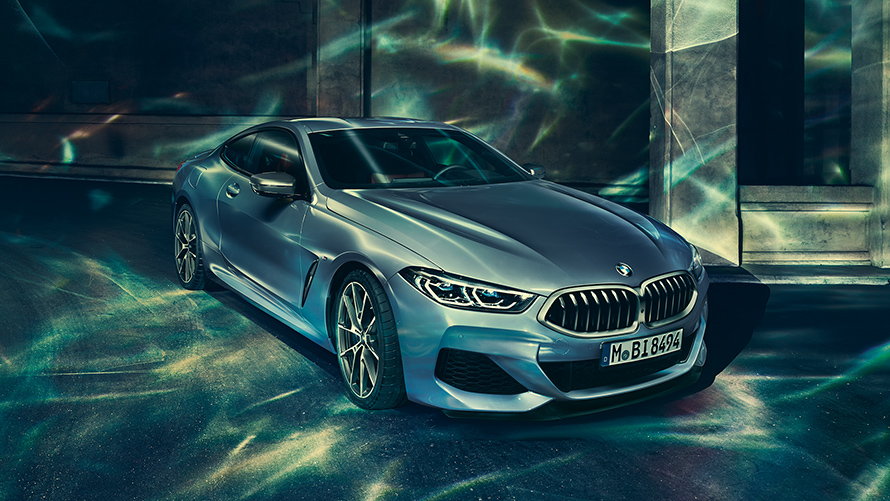 תצלום סטילס במבט חזית-צד שמאל של BMW סידרה 8 קופה בסביבה עירונית.