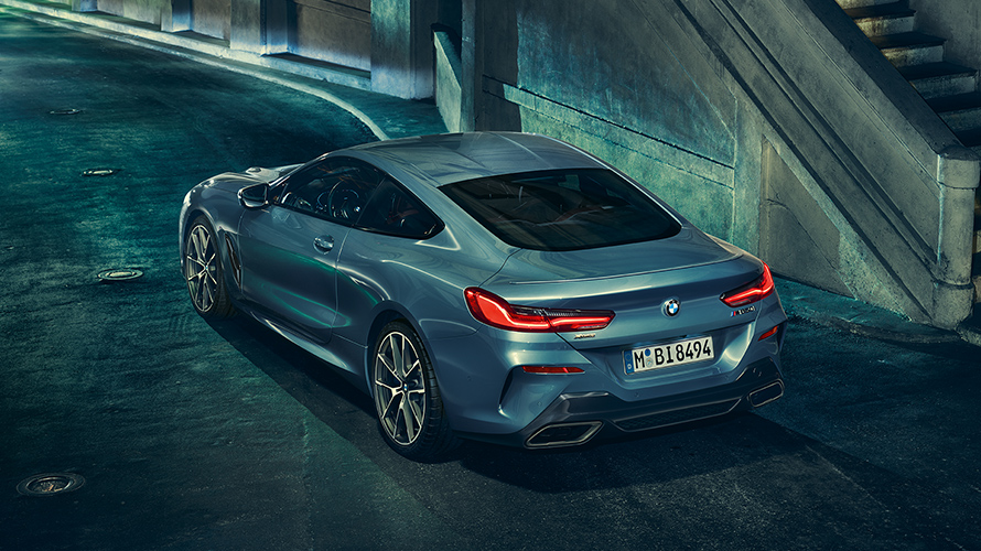 תצלום סטילס במבט אחור-צד שמאל של BMW סידרה 8 קופה בסביבה עירונית.