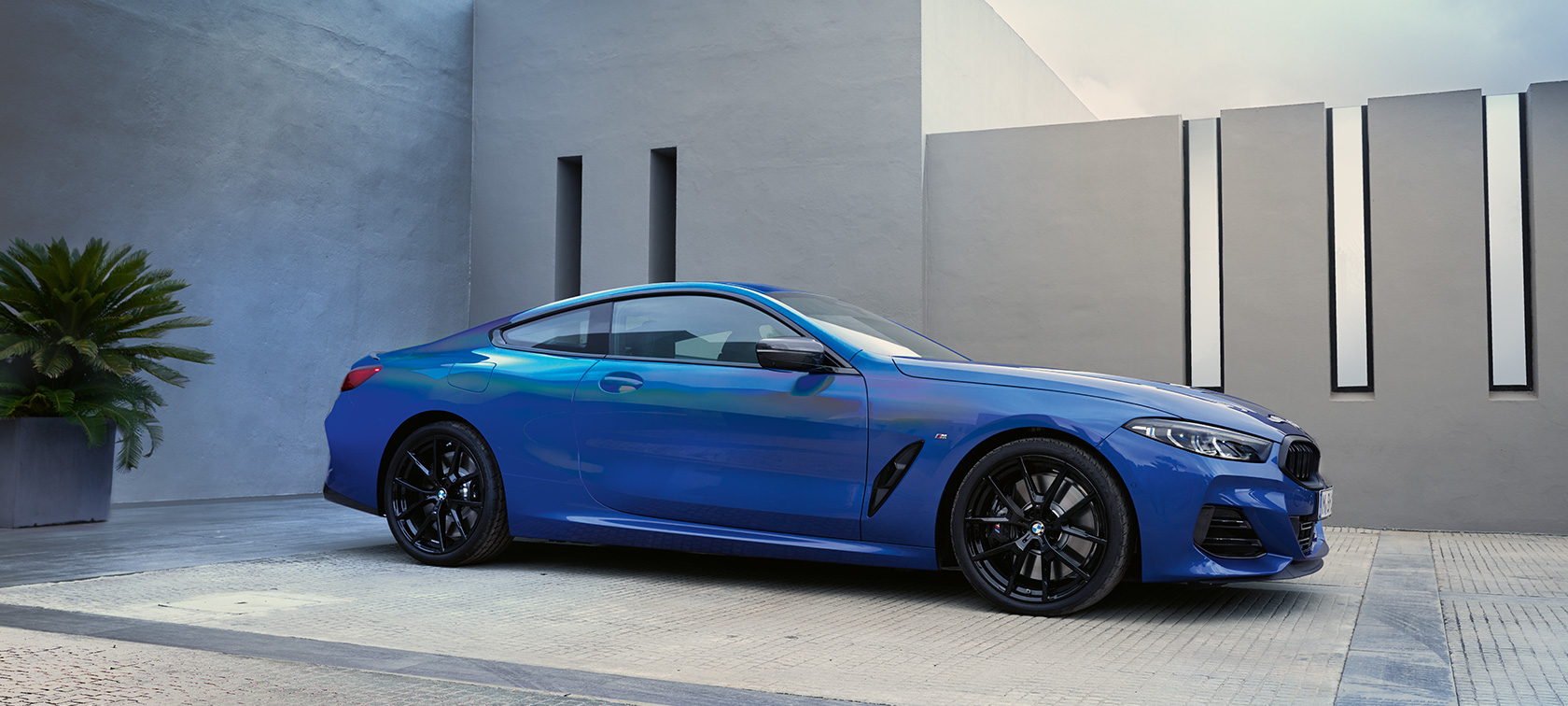 מבט צדדי BMW סדרה 8 קופה LCI מתיחת פנים BMW סדרה 8 קופה LCI מתיחת פנים M Portimao Blue מטאלי מבט צדדי בעמידה לפני בית