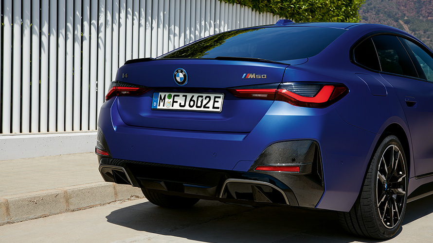 BMW i4 M50 2021 BMW Individual Frozen Portimao Blue מטאלי מבט אחורי ליד גדר לבנה