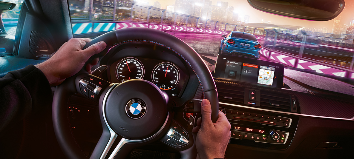 סביבת הנהג של BMW M2 Competition Two BMW M2 Competition in racing situation at night, view from cockpit.