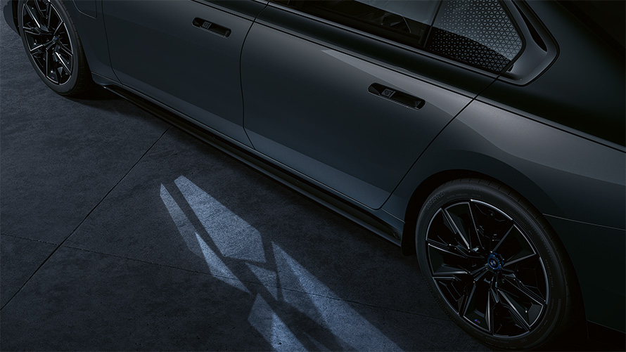 רעיון התאורה BMW M760e xDrive שני גווני שחור מטאלי BMW Individual Black Sapphire אפור BMW Individual Dravite Grey מטאלי מבט צדדי צילום תקריב עם שטיחון תאורת הכניסה דולק