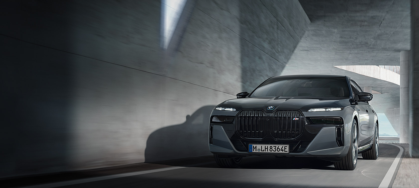 BMW M760e xDrive חבילת M Performance BMW M760e xDrive חבילת M Performance שני גווני שחור מטאלי BMW Individual Black Sapphire אפור BMW Individual Dravite Grey מטאלי מבט קדמי בנהיגה ברחוב
