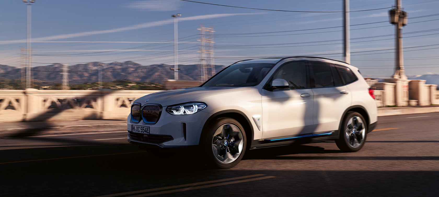 BMW iX3 מבט 3/4 קדמי נסיעה על הכביש ה-BMW iX3 2020 לבן Mineral, מבט 3/4 קדמי נסיעה על הכביש