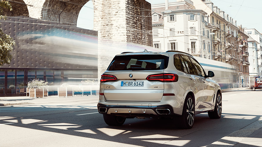 BMW X5 דור רביעי מבט אחורי בעמידה לפני בניין BMW סדרה X BMW X5 דור רביעי מבט אחורי עומד לפני בניין