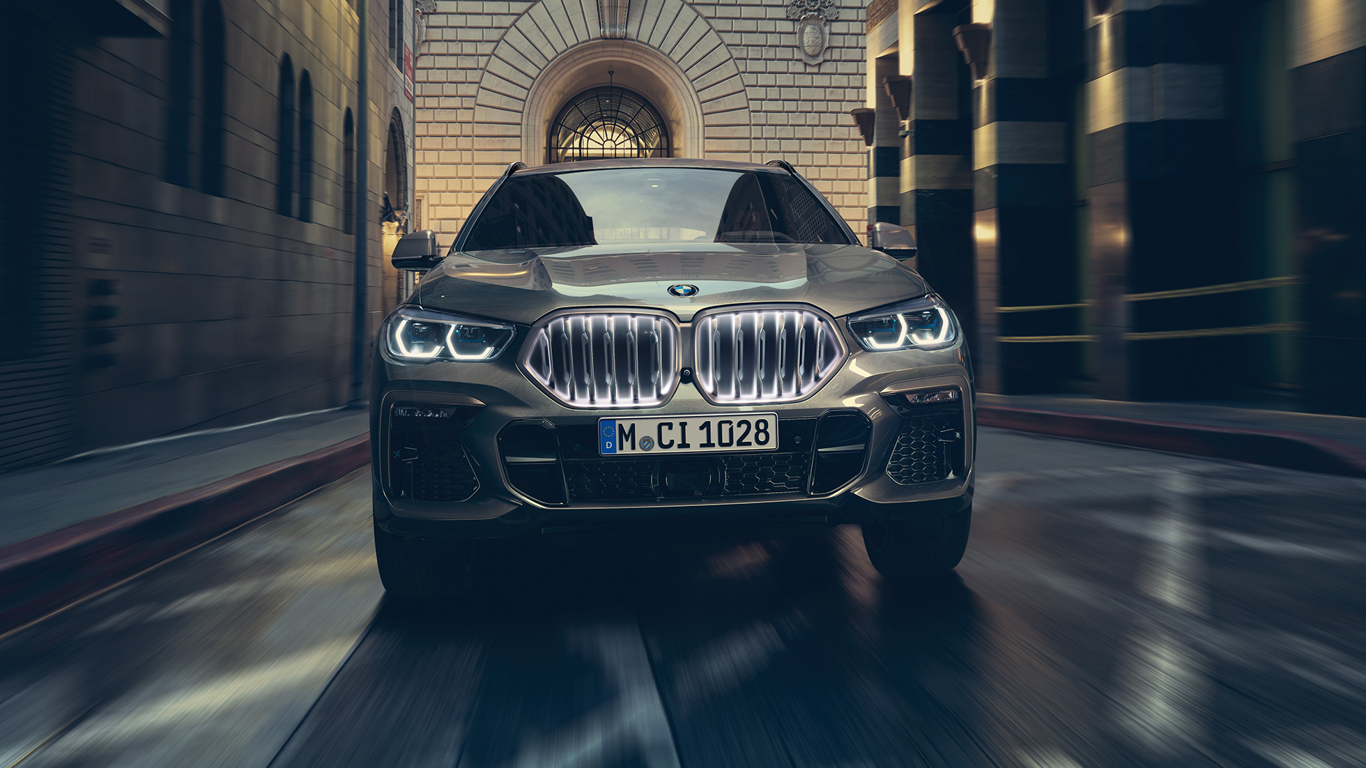 BMW X6 עם גריל הכליות האייקוני המואר. BMW X6 מבט קדמי בסביבה עירונית.