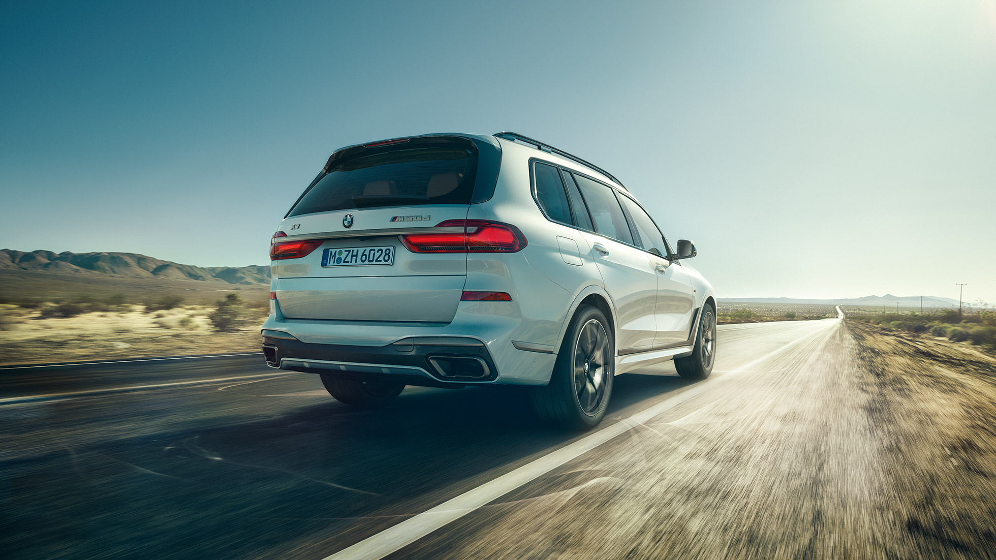 BMW X7 M50d, תצלום מאחור BMW X7 M50d: תצלום מאחור של BMW X7 לבן בנסיעה